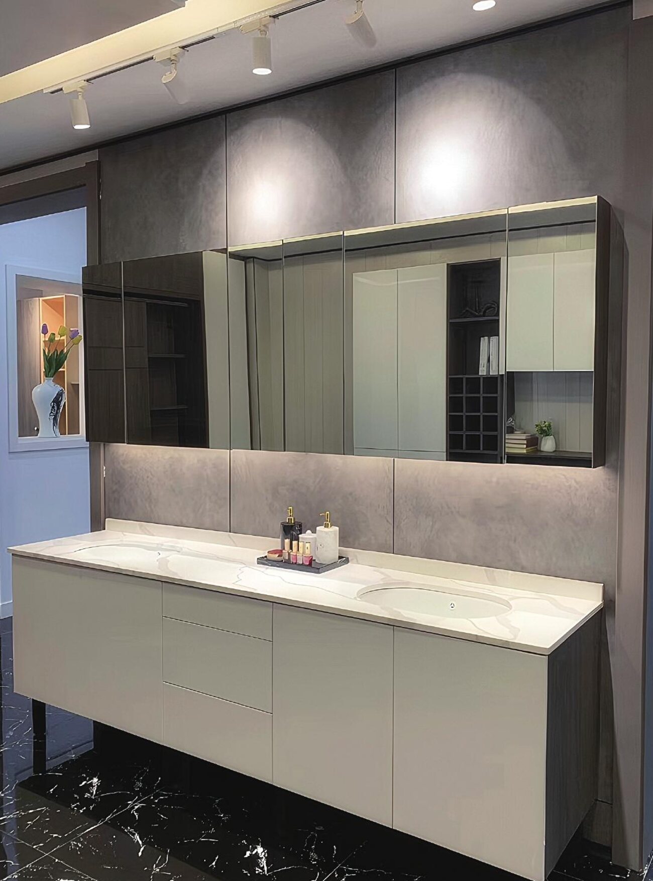Grey floating vanity with mirrored wall cabinets and quartz top